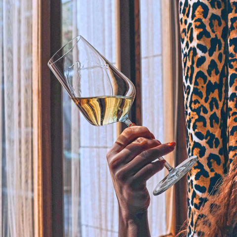 A glass of golden coloured white wine that looks sophisticated. 
